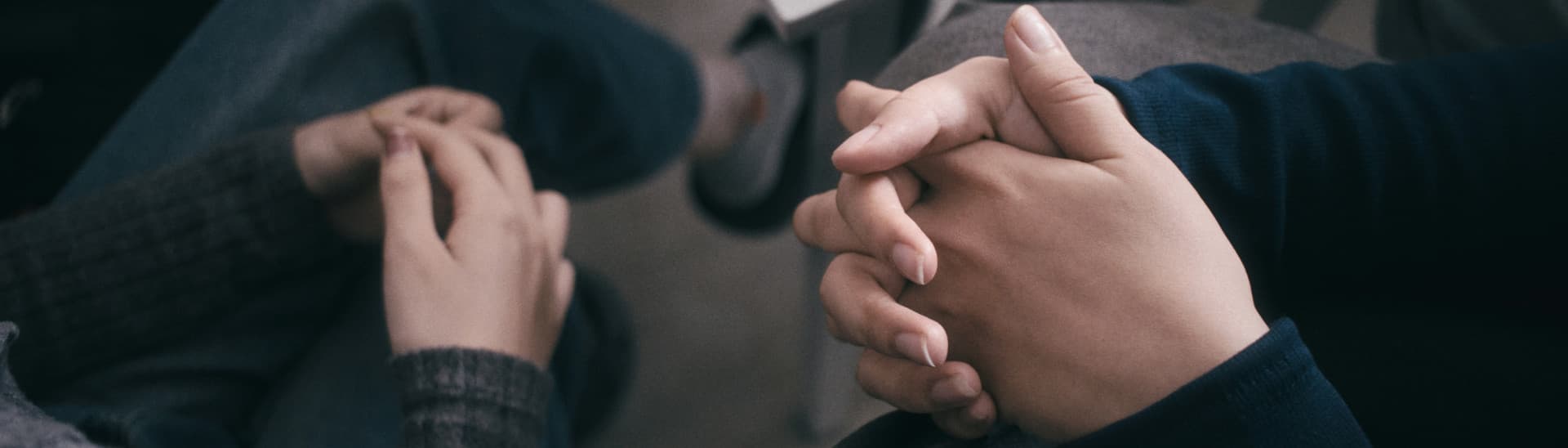 Close view of two people's hands as they sit facing each other